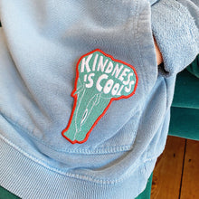 Load image into Gallery viewer, Elephant shaped embroidered kids badge/patch with the words/sloagn &#39;kindness is cool&#39; irons on and then sew into place. Sewn on boys blue jumper.
